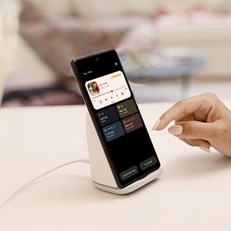 Imagen del teléfono Pixel 6 sobre el Pixel Stand, con el usuario interactuando con la pantalla circundante, incluidas las opciones de carga y el rendimiento en modo silencioso.